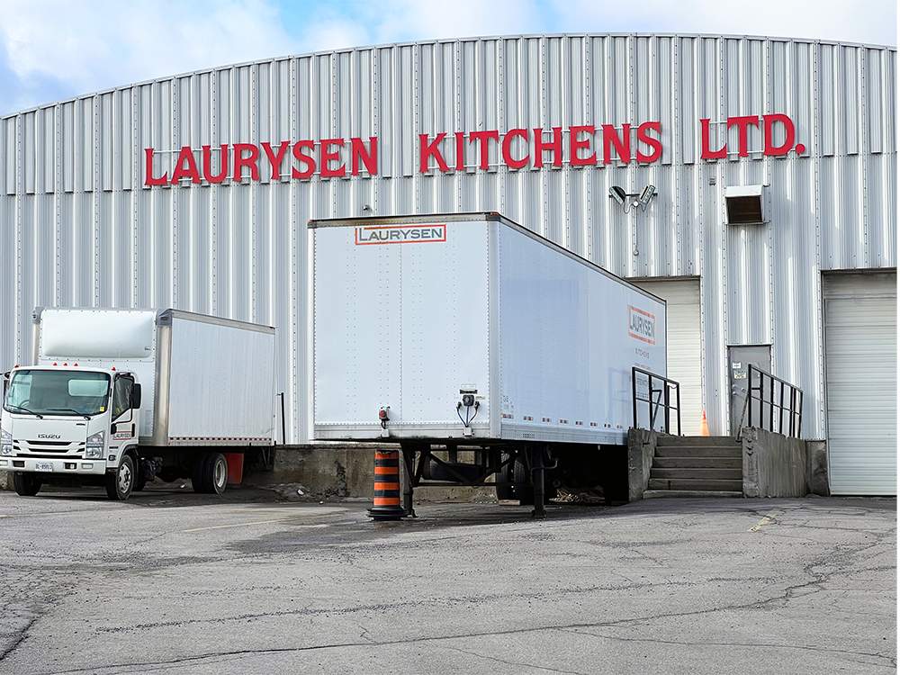 Laurysen Kitchen's warehouse exterior, with a white truck and white shipping container backed up into the loading docks.