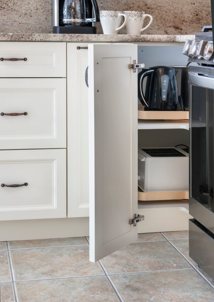 Frameless cabinets maximize interior space, making them ideal for compact kitchens where effective storage solutions are vital, exemplified by this corner cabinet featuring a rotating organizer.